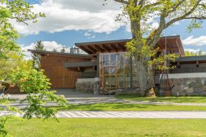 a house with a tree in front of it at Dabas Mājas - Your Dream Holiday Spot in Vecslavēkas