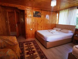 ein Schlafzimmer mit einem Bett in einem Holzzimmer in der Unterkunft Gonul Pansiyon in Kaleucagız