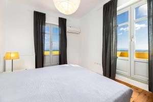 a bedroom with a bed with a view of the ocean at Bralos Villa - Paros, Sea View in Kóstos