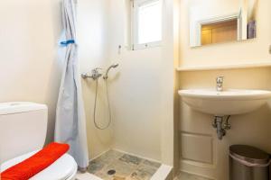 a bathroom with a toilet and a sink and a shower at Bralos Villa - Paros, Sea View in Kóstos