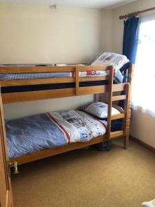 two bunk beds in a room with a window at Parkdean Resorts Bideford Bay Bucklands 21 in Bideford