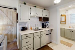 una cocina con armarios blancos y fregadero en Teddy's Getaway, en Ludlow