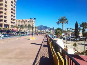 promenada w mieście z palmami i budynkami w obiekcie Piscina - 1ª línea de playa Puerto Deportivo w mieście Fuengirola