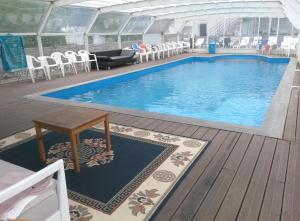 a large swimming pool with chairs and a table at Villa Les Martinets-Chambres Climatisées-Parking Privé-Piscine-Jacuzzi-Brise Fraîche de la Montagne in Le Poujol-sur-Orb