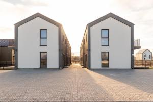 two white houses on a brick road at Amber Stone Apartment 1st floor in Palanga