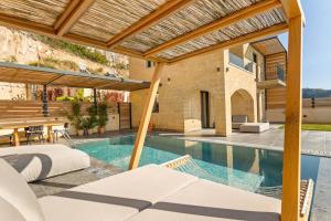 an external view of a villa with a swimming pool at Mani Theasis in Stoupa