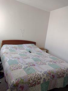 ein Bett mit einer Decke in einem Schlafzimmer in der Unterkunft La serena, Brisas Del Valle in La Serena
