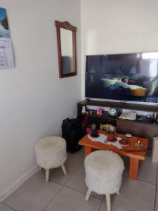 sala de estar con 2 sillas, mesa y TV en La serena, Brisas Del Valle, en La Serena