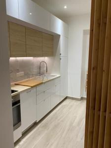 uma cozinha com armários brancos e piso em madeira em Beau studio, 2min walk Monte Carlo Casino, terrace em Beausoleil