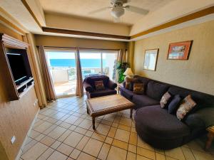 uma sala de estar com um sofá e uma mesa em Las Palmas Resort Condo 603 with amazing sea view em Puerto Peñasco
