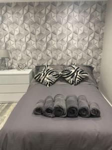 a bed with a gray blanket and pillows on it at Rivendell Modern 2 Bedroom apartment in St Peters village sleeps 6 in Kent