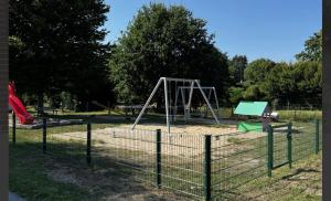 - une aire de jeux avec balançoire dans un parc dans l'établissement Hildas Idyllische Ferienwohnung, à Gödenstorf