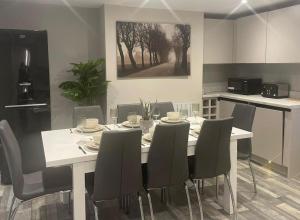 a dining room with a white table and chairs at Rivendell Modern 2 Bedroom apartment in St Peters village sleeps 6 in Kent