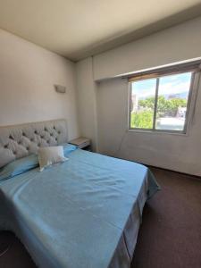 Un dormitorio con una gran cama azul y una ventana en Departamento céntrico Mendoza en Mendoza
