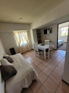 1 dormitorio con 1 cama, mesa y sillas en Departamento céntrico Mendoza en Mendoza