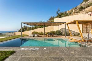 a swimming pool with a pavilion next to a house at Mani Theasis in Stoupa