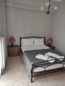 a bedroom with a bed with two lamps and two tables at Averof in Preveza