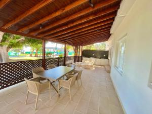 a dining room with a table and chairs on a patio at Dream Beachfront Bungalow in Limassol