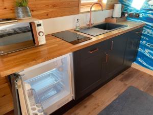 a small kitchen with a sink and a microwave at 4 Sinclair bay lodges in Keiss