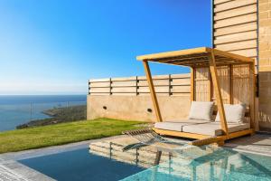a swimming pool with a gazebo next to a house at Mani Theasis in Stoupa