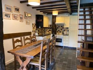 een keuken met een houten tafel en stoelen bij La Petite Passerelle à Mouzaive in Vresse-sur-Semois