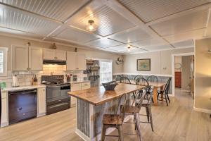 a large kitchen with a wooden table and chairs at Lakefront Greers Ferry Cabin with Covered Boat Slip! in Fairfield Bay