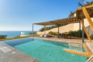a swimming pool with a view of the ocean at Mani Theasis in Stoupa