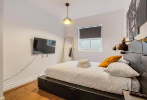 sypialnia z łóżkiem i telewizorem z płaskim ekranem w obiekcie Shoreditch Balcony 2 BDR Apartment w Londynie