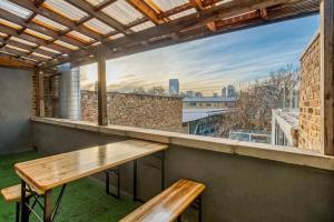 a balcony with a wooden bench and a large window at Shoreditch Balcony 2 BDR Apartment in London