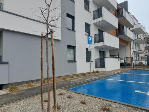 a building with a swimming pool in front of a building at Torpo Apartment with parking in Toruń