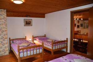 two beds in a room with purple sheets at Apartments Lenc in Bovec