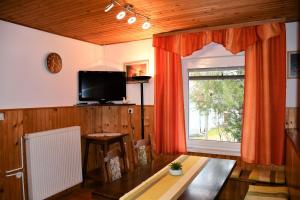 a living room with a television and a table and a window at Apartments Lenc in Bovec