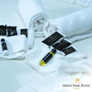 un mucchio di asciugamani bianchi e una penna su un letto di Green Park Hotel a Mercogliano