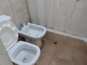 La salle de bains est pourvue de toilettes blanches et d'un lavabo. dans l'établissement Amplio Departamento en San Rafael, à San Rafael