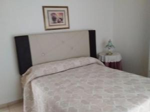 - une chambre avec un lit et une table avec une photo dans l'établissement Amplio Departamento en San Rafael, à San Rafael