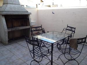 une table en verre avec quatre chaises et une cuisinière dans l'établissement Amplio Departamento en San Rafael, à San Rafael