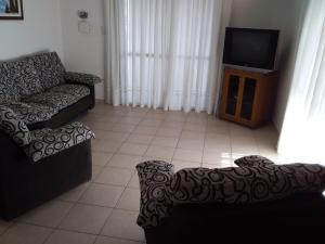 - un salon avec un canapé et une télévision dans l'établissement Amplio Departamento en San Rafael, à San Rafael