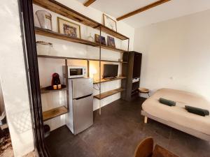 a small room with a refrigerator and a couch at Charmant studio loft - Mas Bois Fontaine in Nîmes