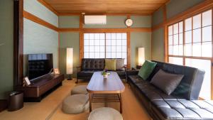sala de estar con sofá y mesa en OriOri House Hotel Mt Fuji view 全室富士山ビューの貸切り宿 折々 en Fujikawaguchiko