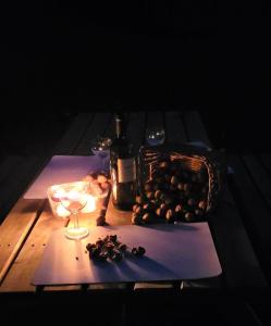 a table with a glass of wine and a basket of grapes at Villa Glory Mountain Lake Iseo Hospitality in Bossico