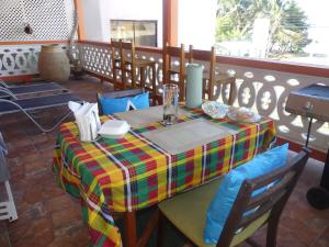 a table with a colorful table cloth on a balcony at Southern Haven Guesthouse in Laborie