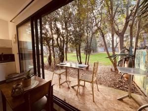 a room with a table and chairs and a large window at Charmant studio loft - Mas Bois Fontaine in Nîmes