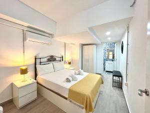 sypialnia z dużym łóżkiem i żółtym kocem w obiekcie Duplex Huelin III & Beach by ELE Apartments w Maladze