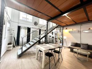 loft ze schodami, stołem i krzesłami w obiekcie Duplex Huelin III & Beach by ELE Apartments w Maladze