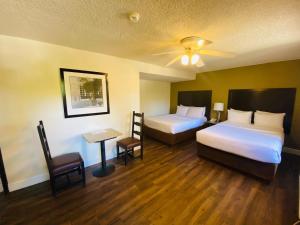 a hotel room with two beds and a table at Hotel America in Tijuana