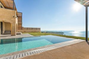 a swimming pool with a view of the ocean at Mani Theasis in Stoupa