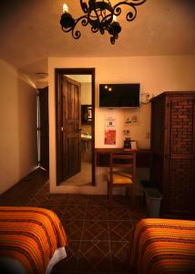 a room with a bedroom with a desk and a mirror at La Escondida Hotel Boutique in Zacatlán