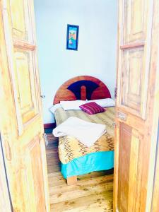sypialnia z 2 łóżkami i otwartymi drzwiami w obiekcie Ukumari Hostel w Cuzco