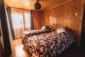 a bedroom with two beds and a window at Hostel Antawara in Vicuña