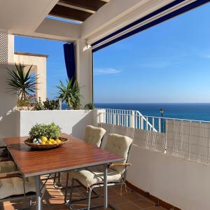 a table on the balcony with a view of the ocean at RESIDENCIAL OASIS 2 in Mojácar